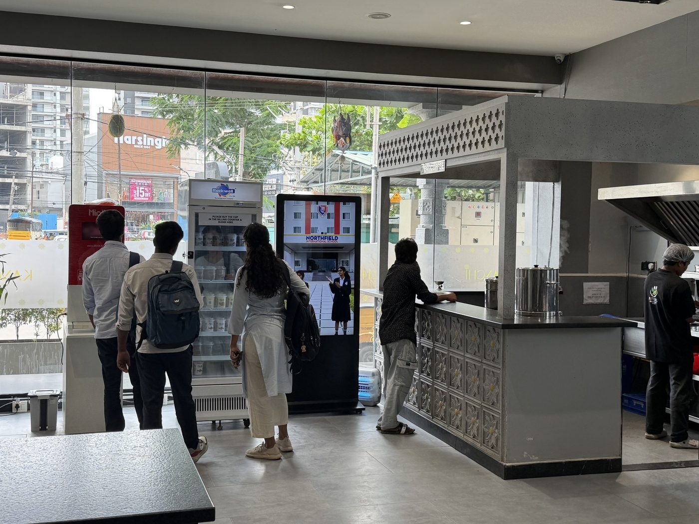 KMEDIA standee running ads inside a modern cafe